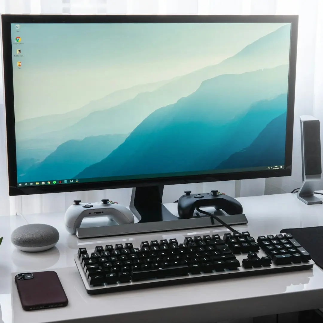 black computer keyboard beside silver imac