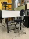 Mesa de dibujo de madera, equipada con una regla paralela, una bandeja lateral y un taburete metálico