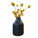 Florero negro con flores amarillas